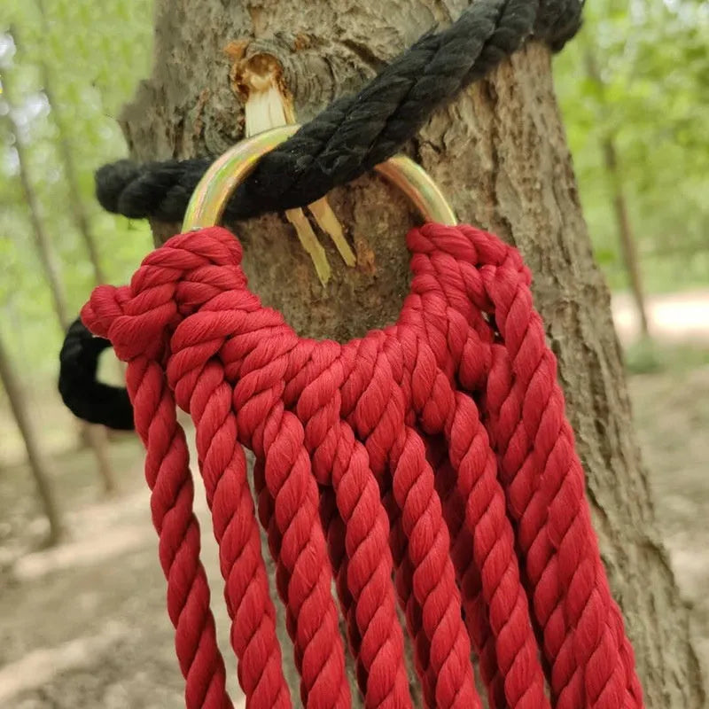 Outdoor bold style nylon rope mesh hammock shown in a garden setting
