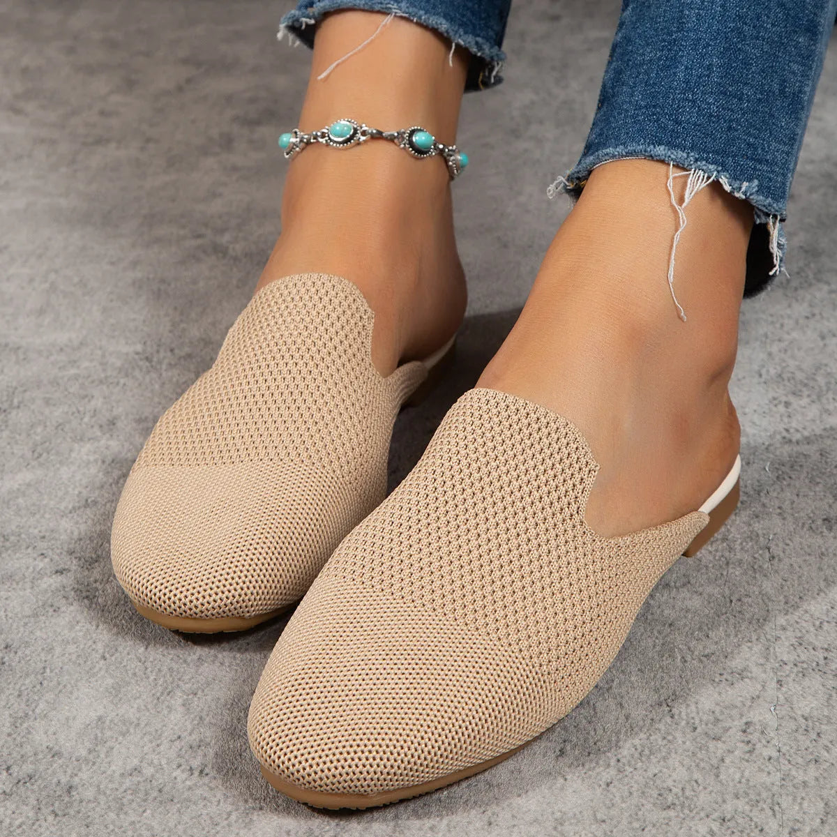 Apricot coloured mesh slip-on sandals with a round toe and flat rubber sole on a white background