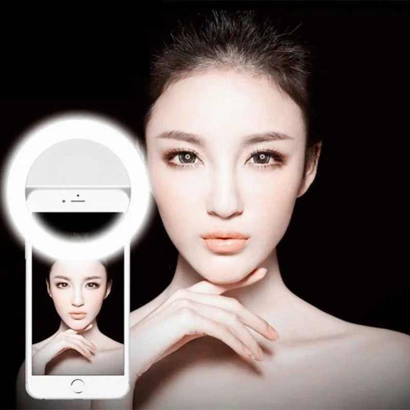 Mobile phone with clip-on selfie ring light showing LED illumination for photography