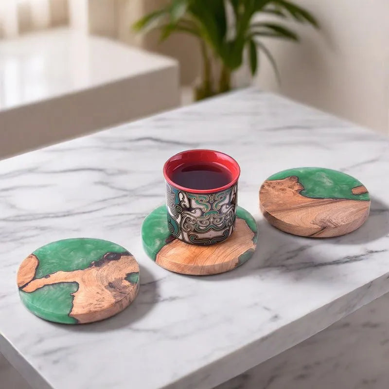 Set of four solid-colour wooden coasters in irregular round and square shapes on a wooden table.