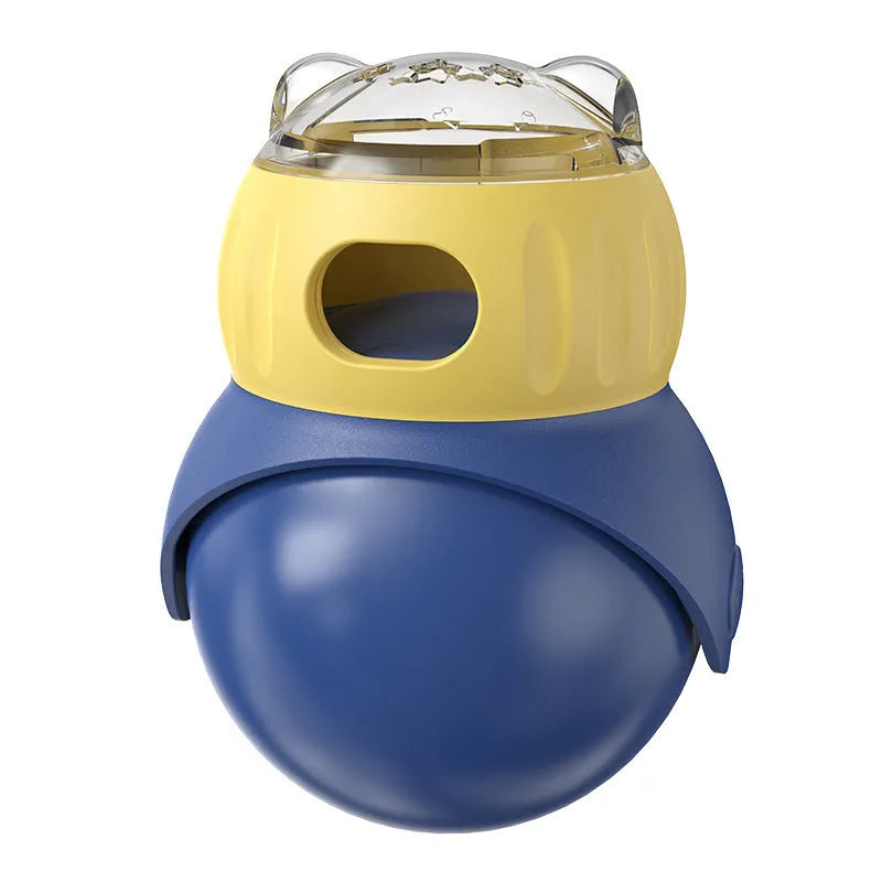 Owl-shaped yellow and blue plastic puzzle feeder for cats on a wooden floor.