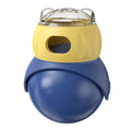 Owl-shaped yellow and blue plastic puzzle feeder for cats on a wooden floor.