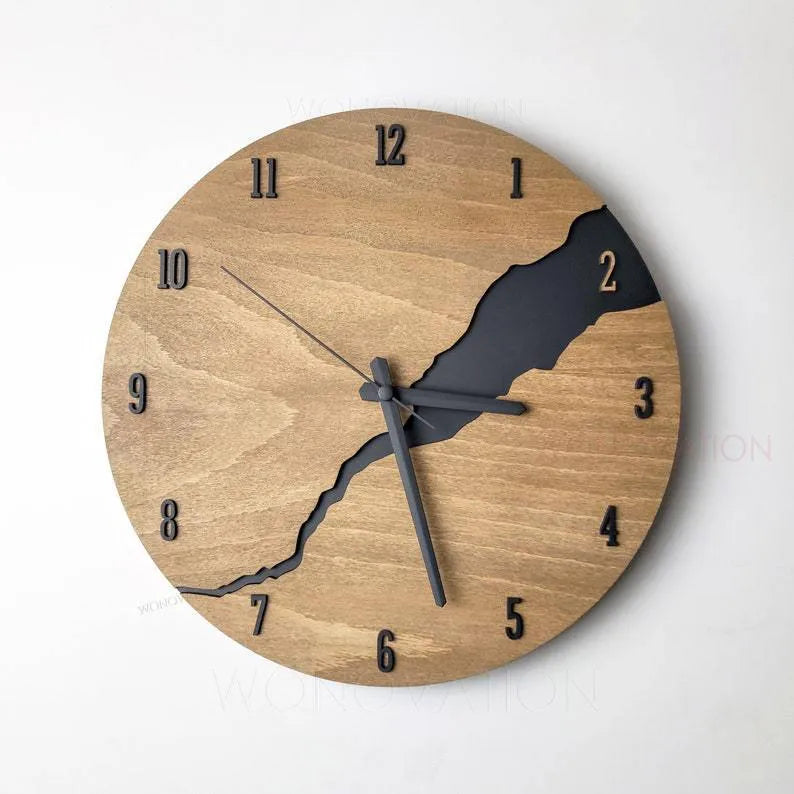 Modern simple wooden wall clock with a crack design dial on a light wood background.