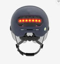 Cycling helmet with integrated red LED brake light on the rear, shown in two style variations.