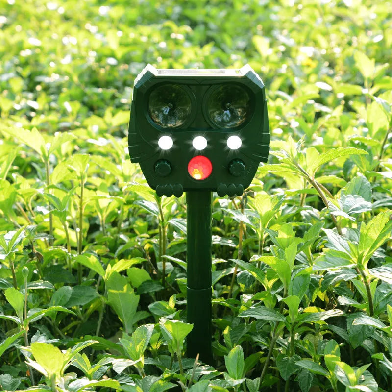 Green solar-powered ultrasonic animal repeller unit for outdoor pest and dog control.