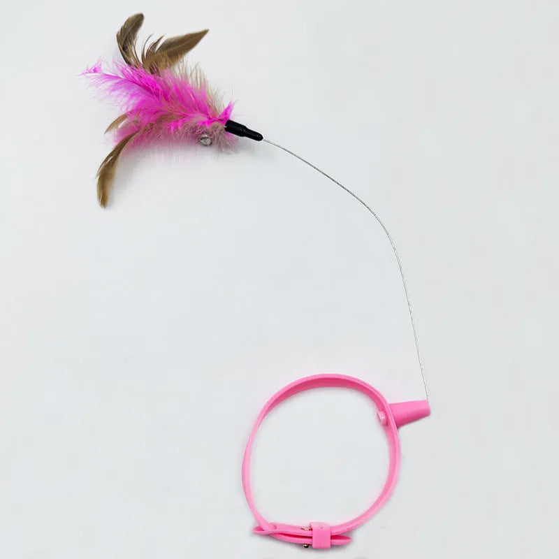 Pink and blue adjustable collar cat teaser toy with feather and bell attachment on a white background