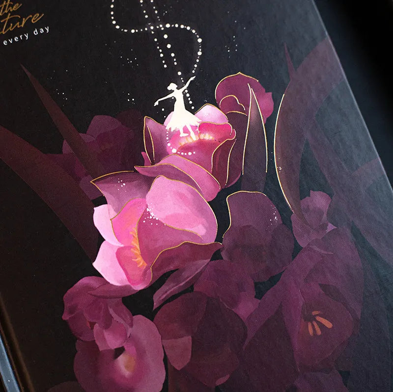 A5 notebook with luminous reflective cover open to show pages with colourful illustrated backgrounds.