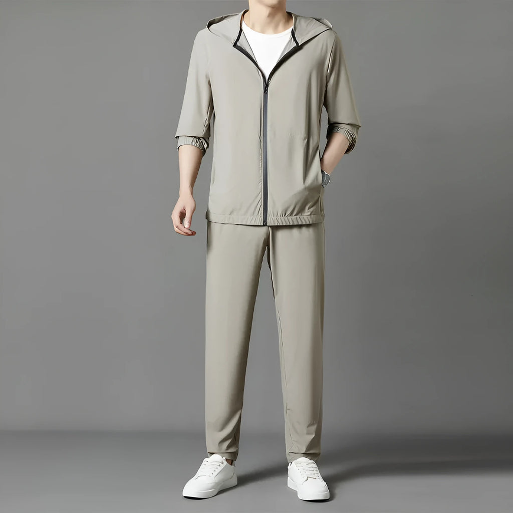 Grey loose-fit hooded sun-protective jacket and trousers set on a hanger