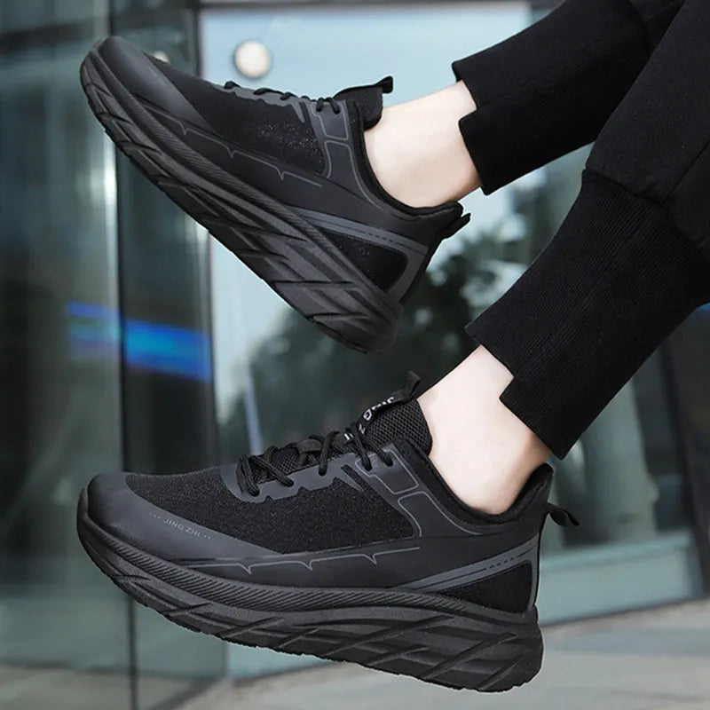 Men's black thick-soled anti-skid lace-up running sneakers with round toe and rubber sole on grey background