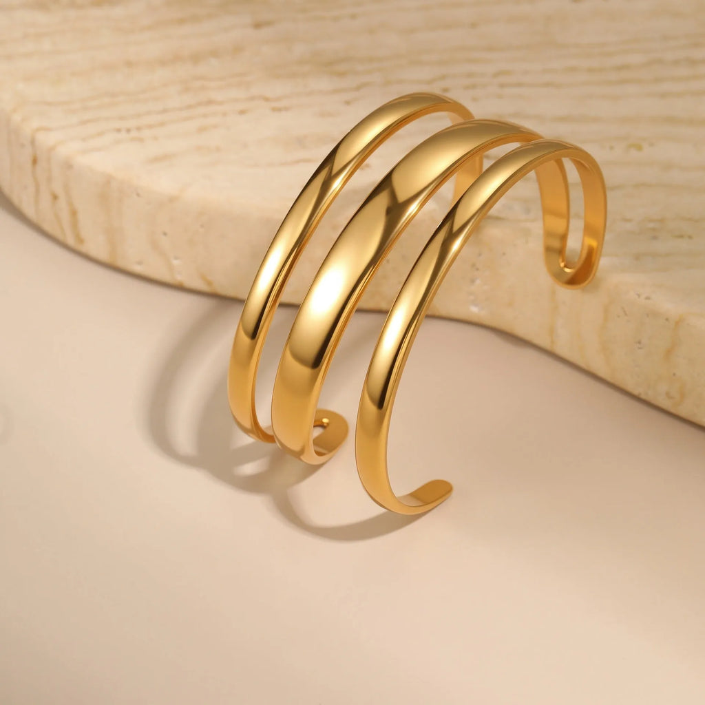 Geometric line design stainless steel bracelet with simple opening clasp, shown in gold and steel colour options.