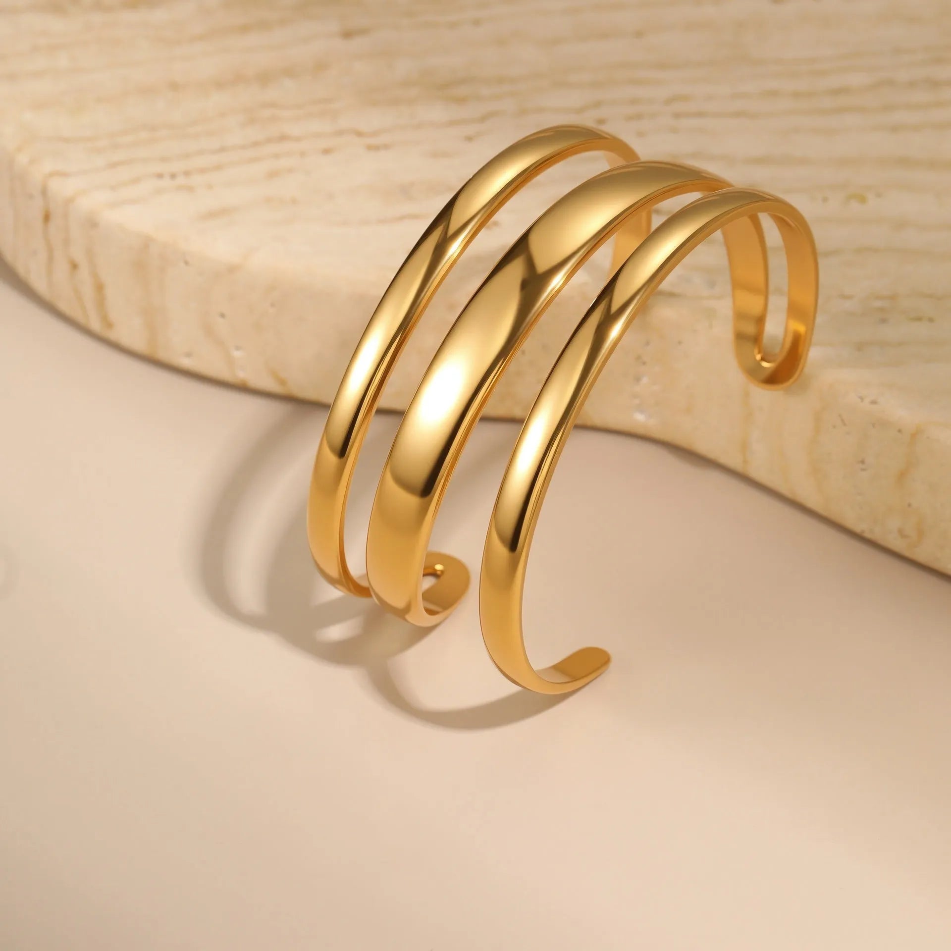 Geometric line design stainless steel bracelet with simple opening clasp, shown in gold and steel colour options.