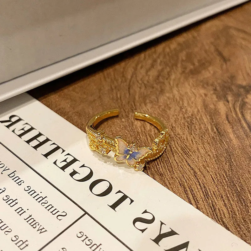 Creative butterfly design women's ring in copper with oil drip finish, showing an open loop style.