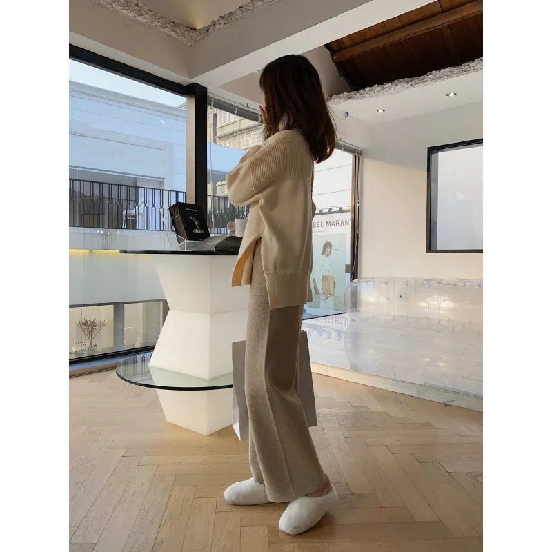 Women's high-waisted knitted wide-leg trousers in black, shown in a casual setting.