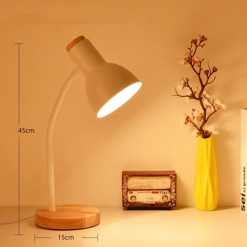 A simple modern Nordic style LED desk lamp with a dimmer switch on a desk.