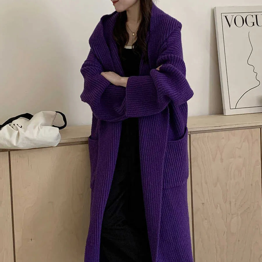 A woman wearing a loose, milky white hooded cardigan coat with raglan sleeves.