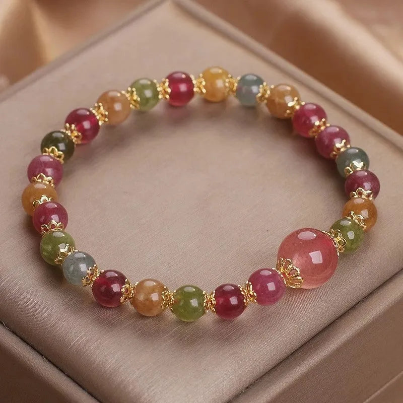 Close-up of a beaded bracelet with round strawberry quartz and tourmaline stones, 10mm in size.