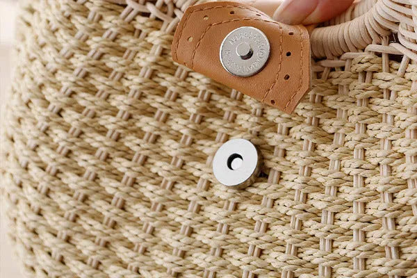 Women's round woven paper rope handbag in beige with hard shell, cover closure, and hard handle