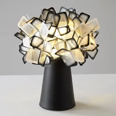 Nordic style decorative table lamp in a choice of colours including black, blue, and orange on a wooden surface.