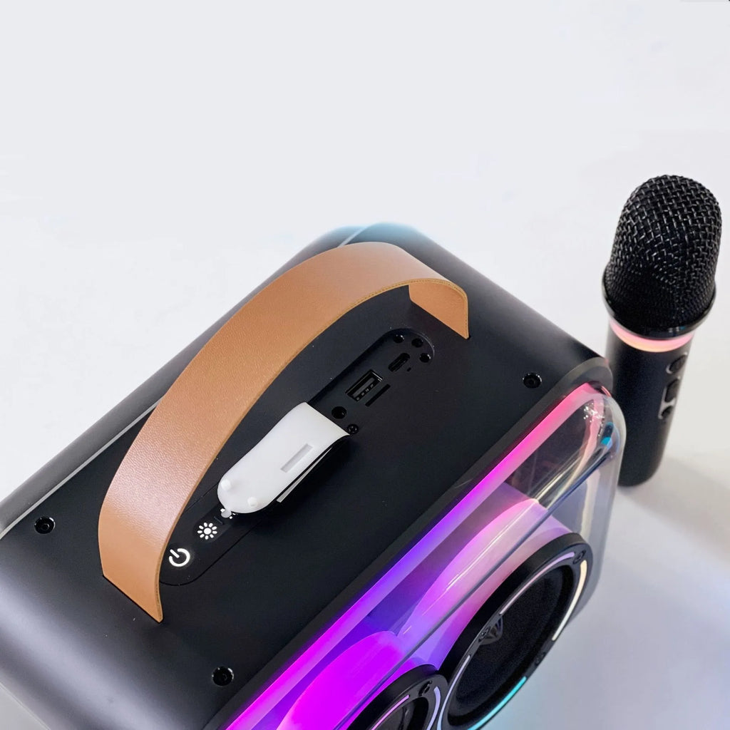 Light yellow portable Bluetooth speaker with RGB lighting and a wireless microphone on a table