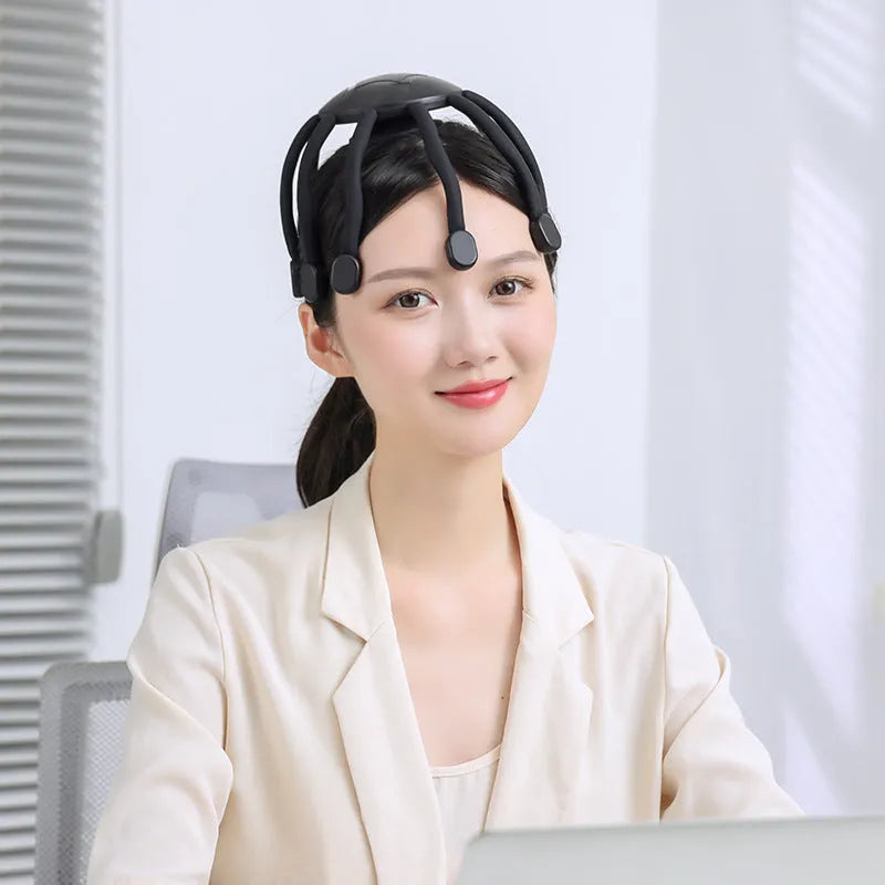 Black and white head massagers with multiple vibrating claws on a stand.