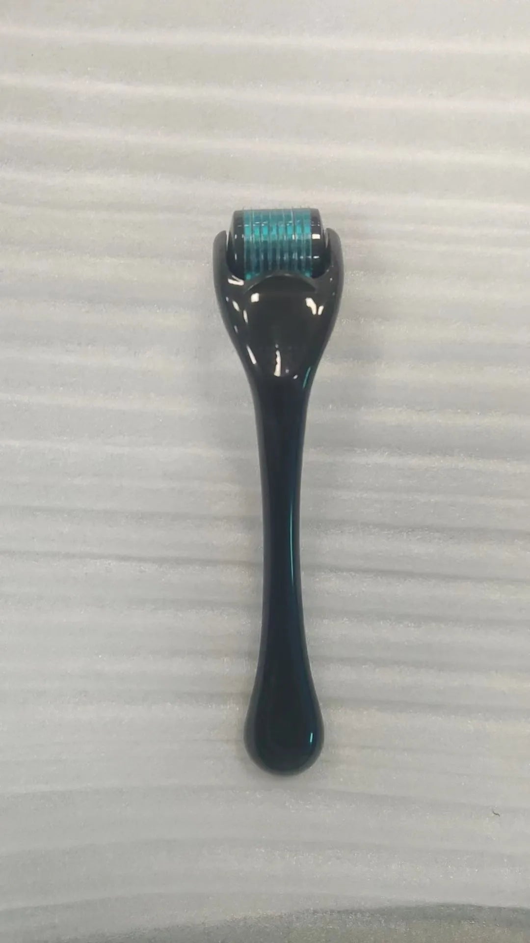540 micro needle roller tool with black handle and coloured wheel on a white background.