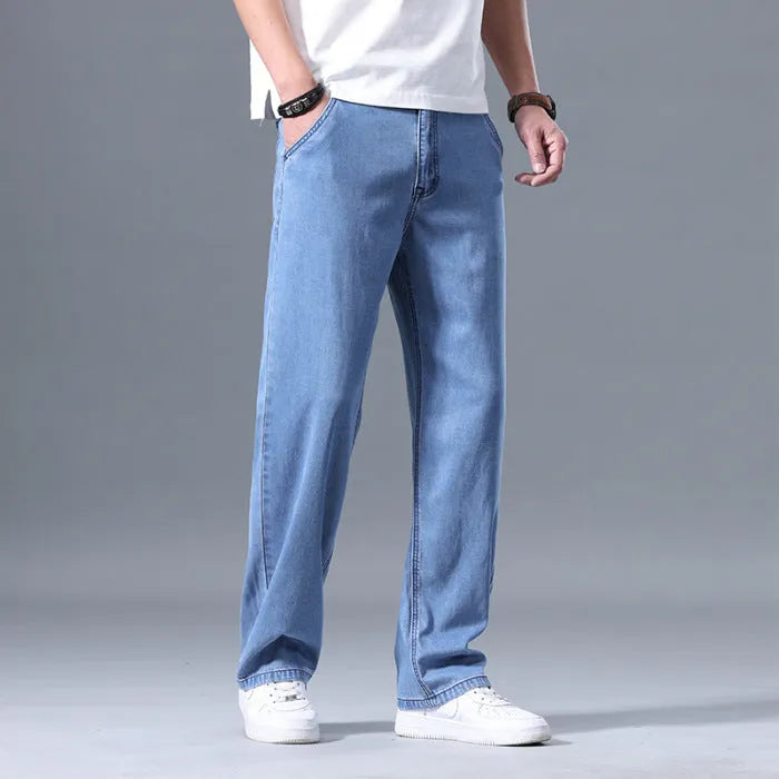Man wearing light blue loose-fit straight-leg lyocell jeans with a zip fly