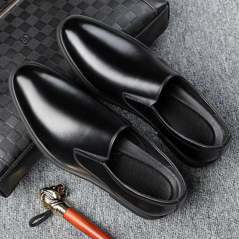 Men's black low-top slip-on leather shoes with a rubber sole and sewing line detailing.