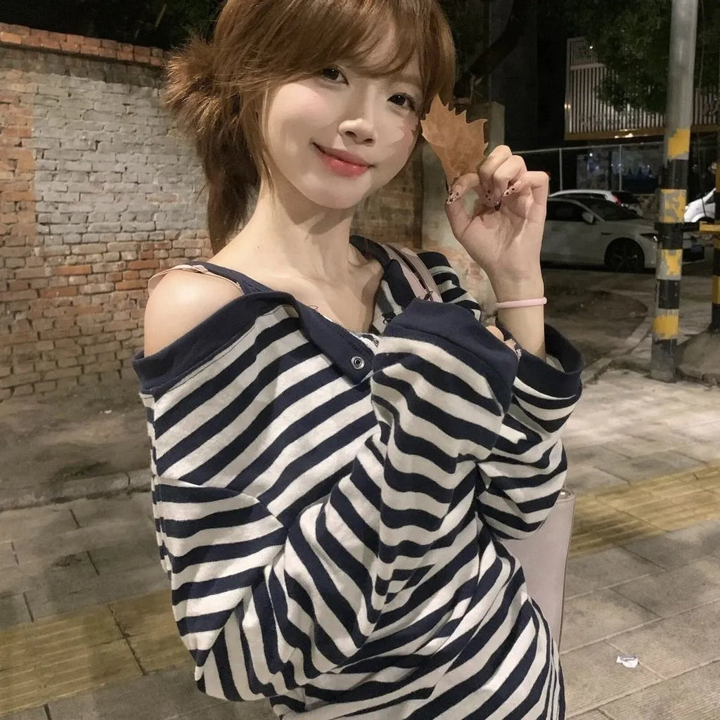 Dark blue women's oversized long-sleeve t-shirt with embroidery and stripe details on a hanger.