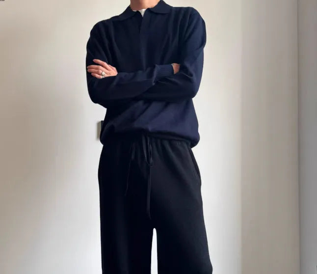 Pure wool polo sweater with lapel collar in navy blue on a hanger.