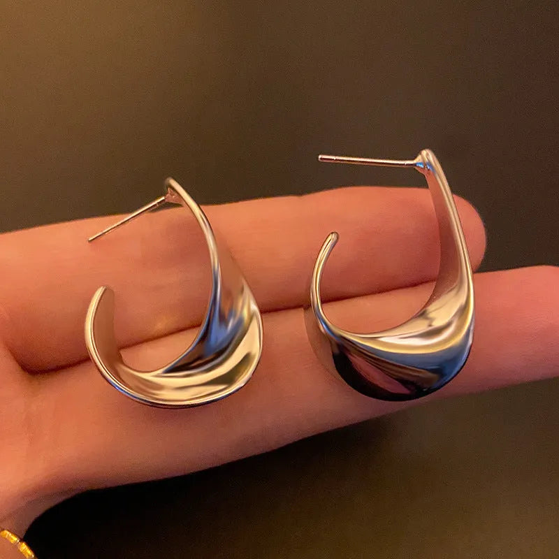 Geometric twist design metal earrings in gold or silver finish with round elements