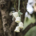 Green and white knitted wool car plant ornament with hanging rope.