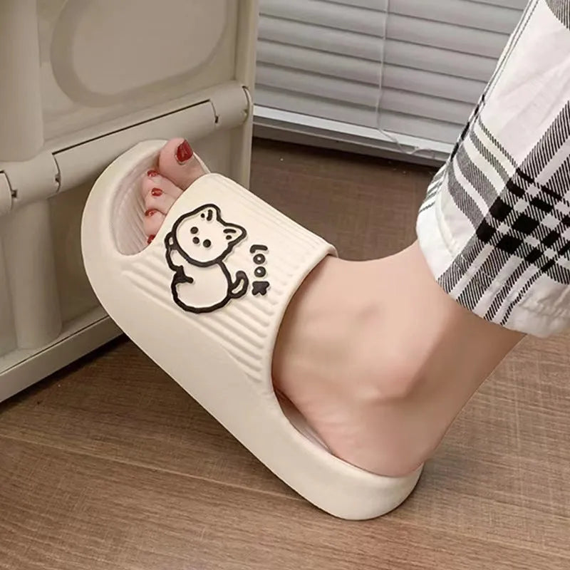 Women's pink EVA cat slippers with thick platform sole on a wooden floor.