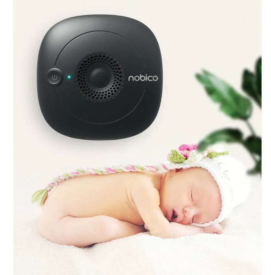 Black and wood grain handheld ultrasonic bed vacuum cleaner on a mattress.