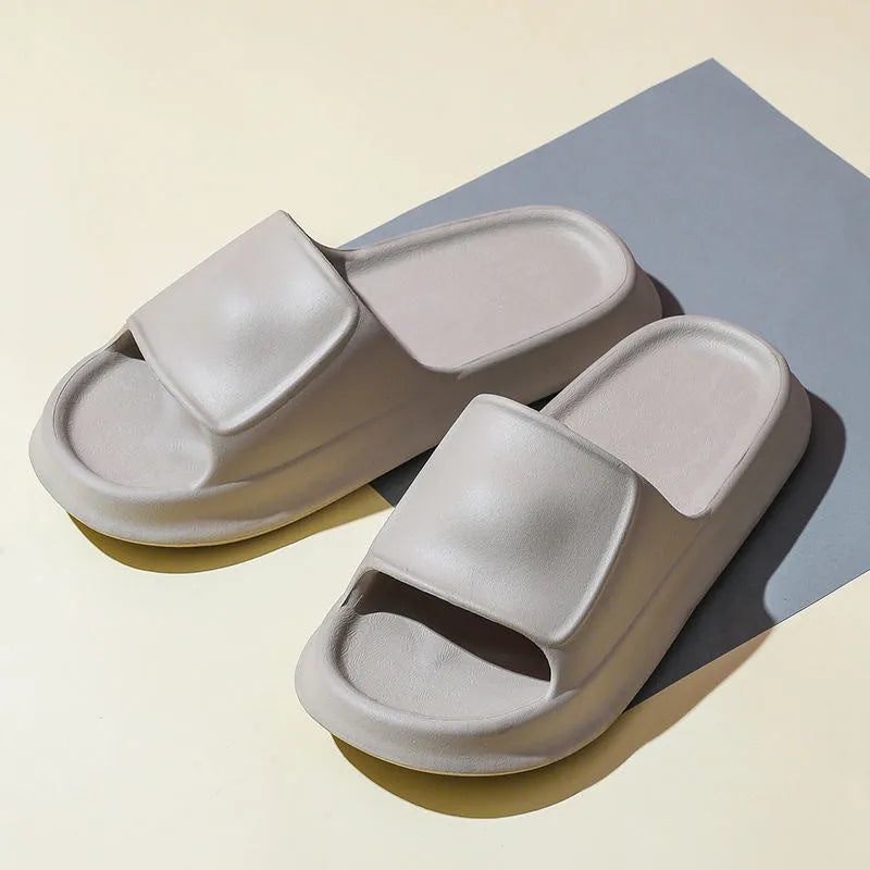 A pair of thick-soled EVA flip-flop slippers on a bathroom floor, showcasing non-slip tread and available colour options.
