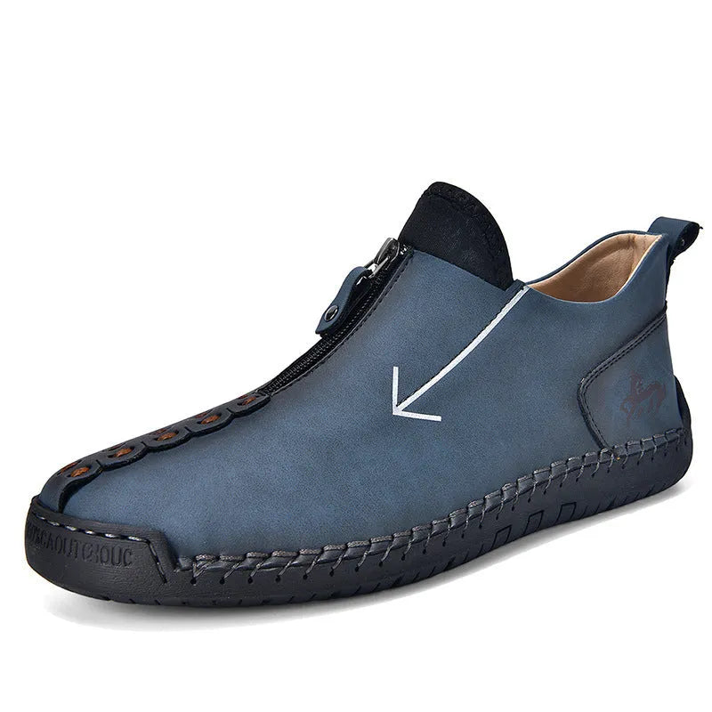 Men's black leather ankle boots with a front zip and hand-stitched detailing on a rubber sole.