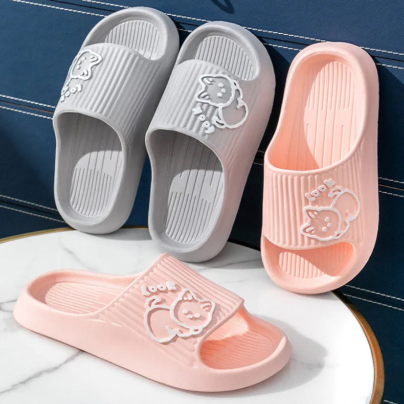 Women's pink EVA cat slippers with thick platform sole on a wooden floor.