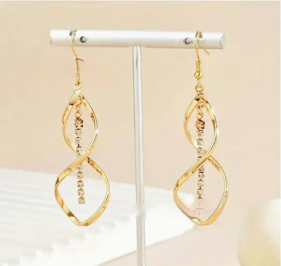 A pair of gold-coloured spiral design earrings with a geometric ellipse shape for women.