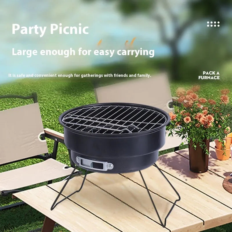 Small round metal folding stove with barbecue grill and mesh, set up for outdoor cooking.