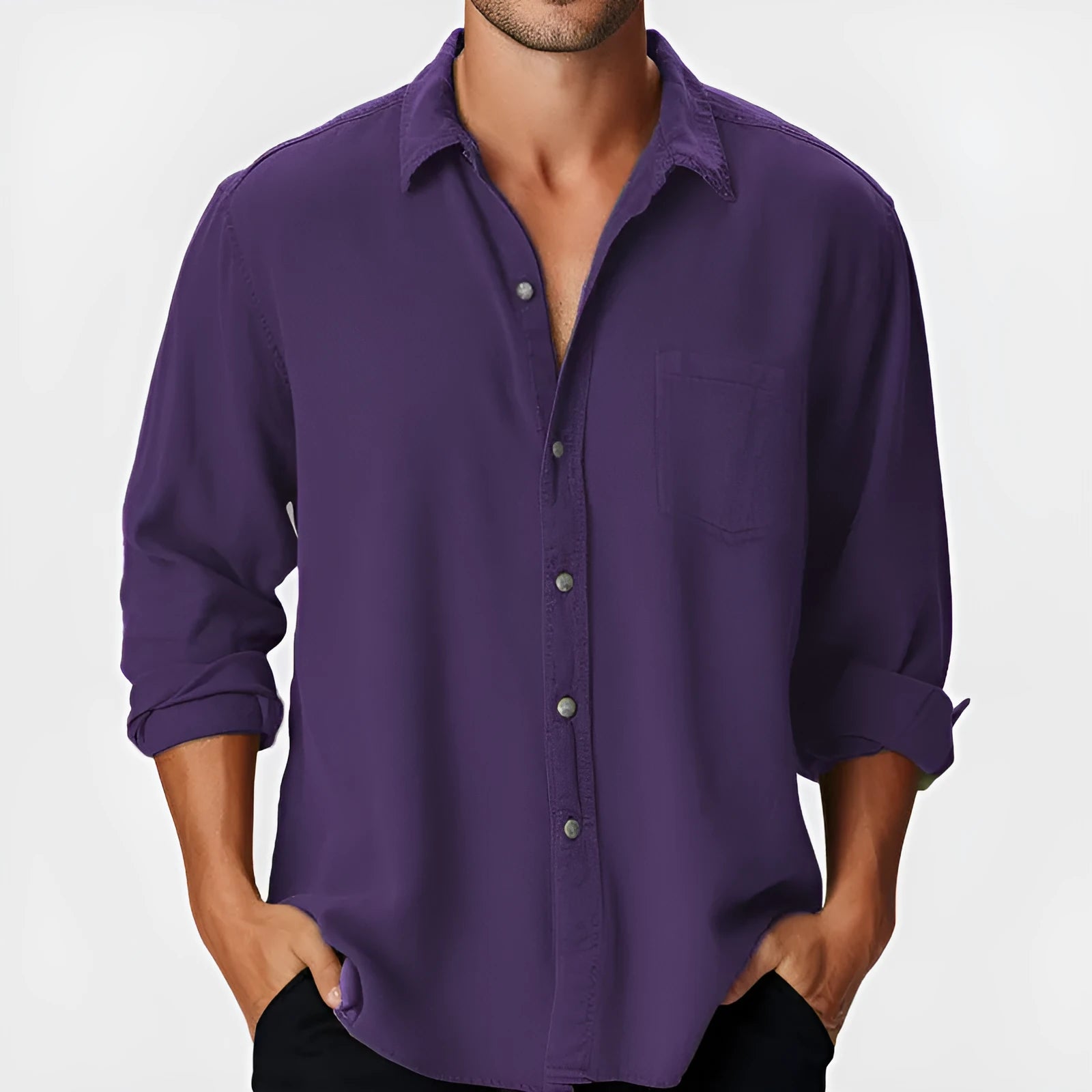 Man wearing a loose fit long sleeve shirt with a stand collar on a beach.