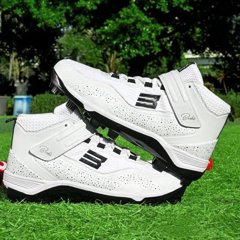 Black and white middle top baseball shoes with Velcro straps and a rubber sole.