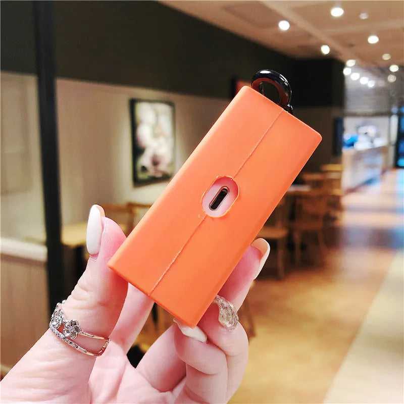 Silicone anti-drop earphone case for Apple AirPods 1 and 2 in black or orange, clamshell bag shape.