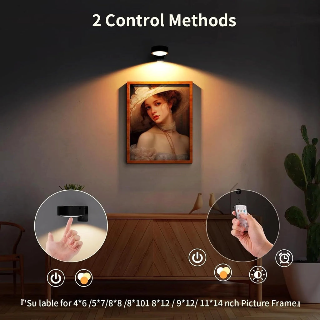 Black magnetic wireless LED lamp with remote control mounted next to a painting on a wall.