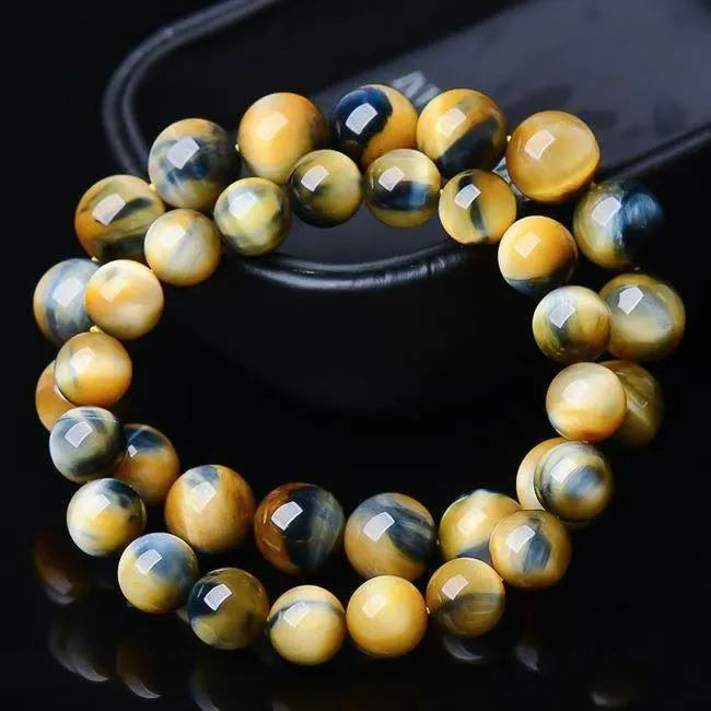 Fantasy tigereye agate bracelet with round beads on a wrist, showing natural stone patterns.