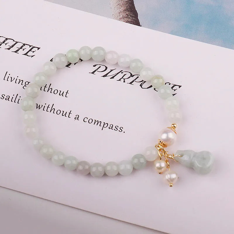 Traditional Chinese style jade bracelet with raised gourd design and pearl accents on green stone