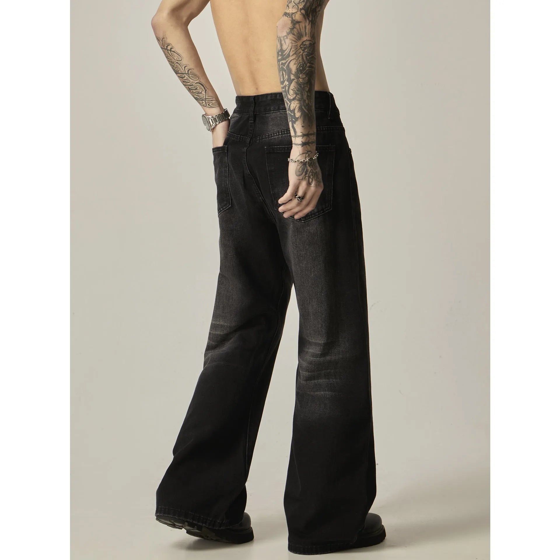 Black loose straight-leg jeans with a retro light wash and zip fly closure laid flat.