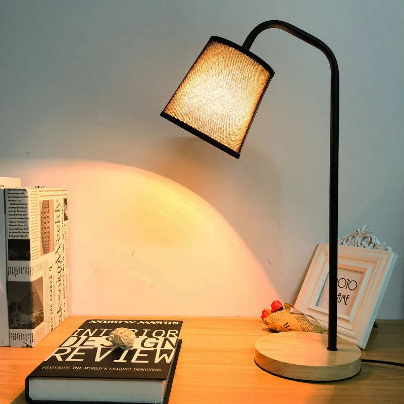 A simple modern Nordic style LED desk lamp with a dimmer switch on a desk.