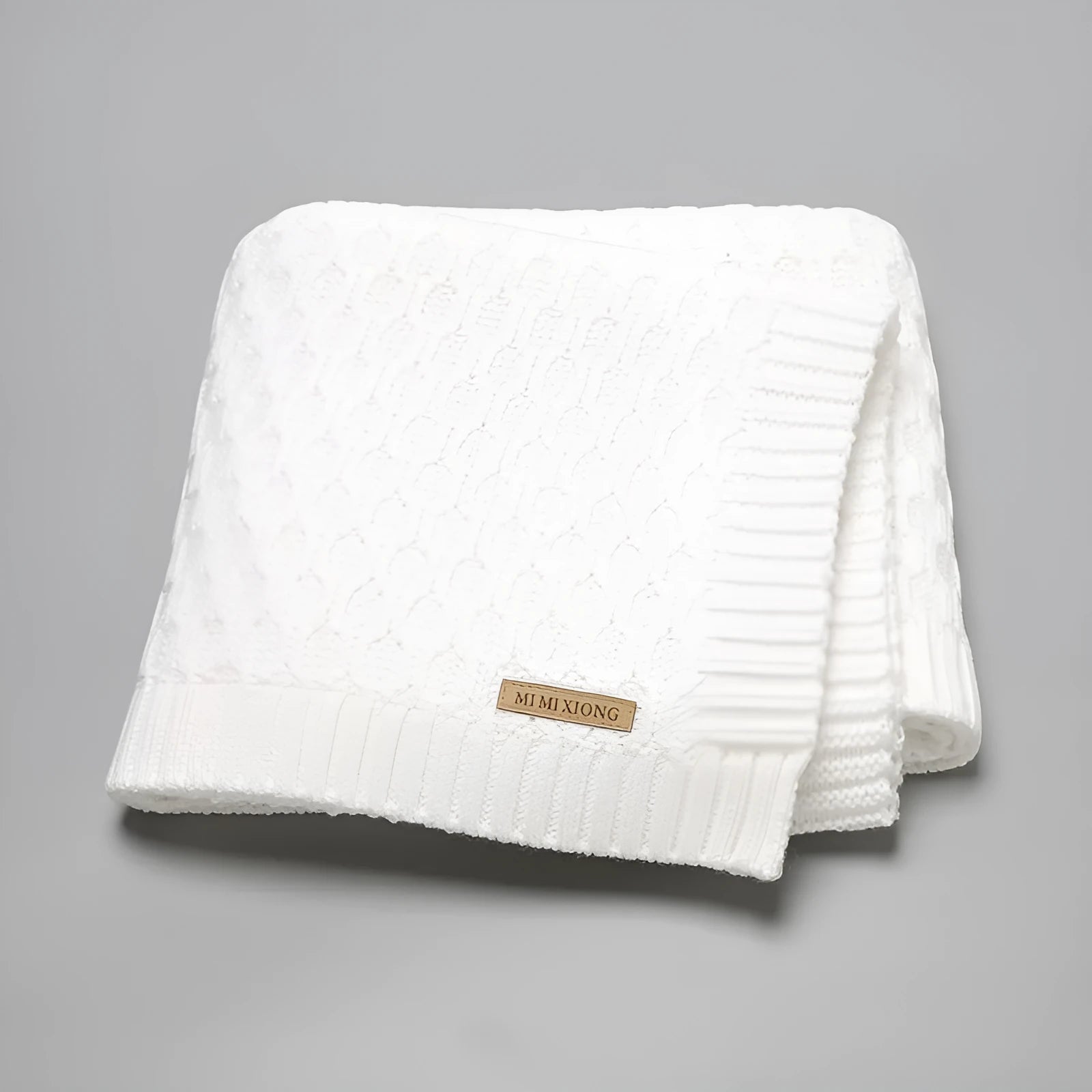 Solid colour infant hug blanket with textured three-dimensional lines pattern.