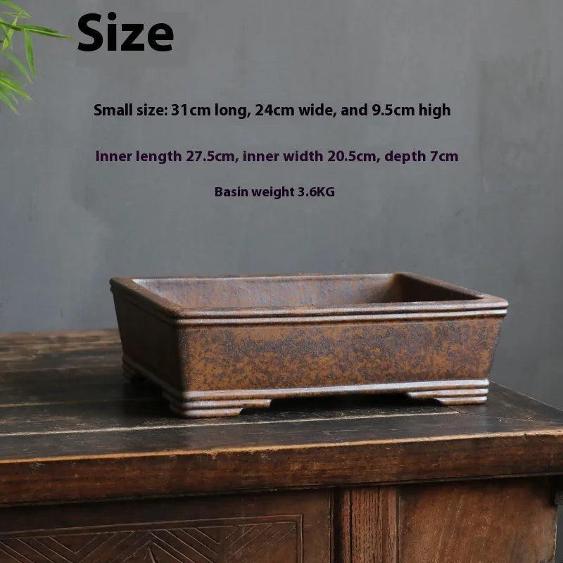 Handmade rectangular purple sand bonsai pot with natural firewood-burnt glaze, shown empty on a wooden surface.