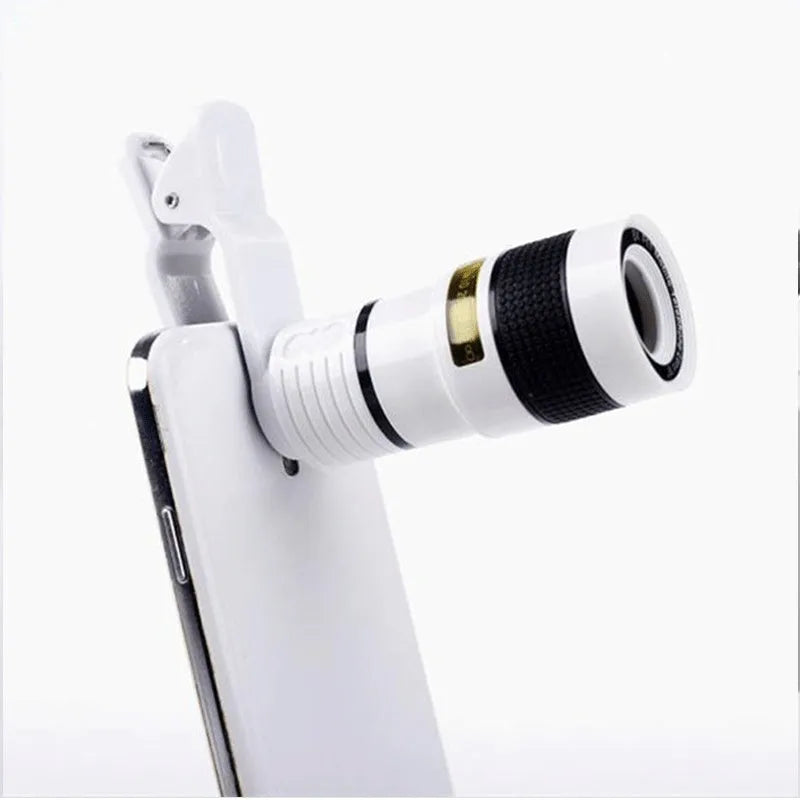 Black 12X smartphone telephoto lens with adjustable mounting clip and cleaning cloth on a table.