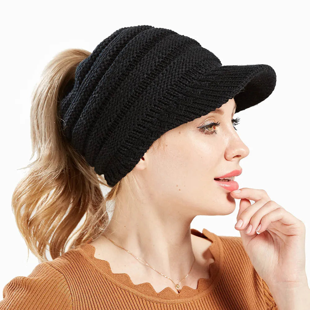 Acrylic knitted ponytail beanie hat for women in a neutral colour, shown on a model with a high ponytail.